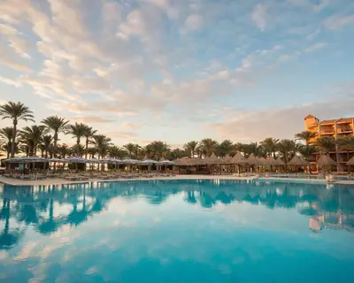 a pool at a resort with palm trees and umbrellas at Siva Grand Beach in Hurghada