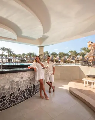 a man and a woman standing next to a wall at Siva Grand Beach in Hurghada