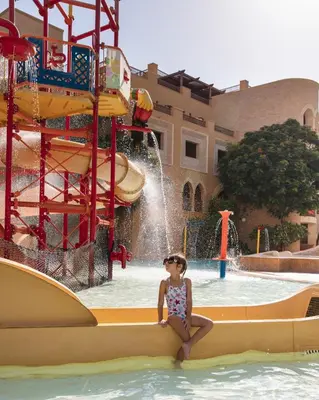 a little girl sitting on a raft in a water park at Grand Waterworld Makadi - Couples and Families Only in Hurghada