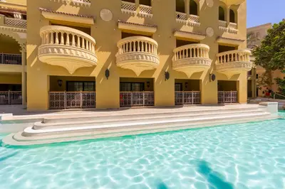 a hotel with a swimming pool in front of a building at Grand Waterworld Makadi - Couples and Families Only in Hurghada