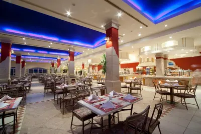 a restaurant with tables and chairs and a bar at Hurghada Coral Beach Hotel in Hurghada
