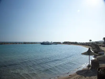 a beach with a large boat in the water at Hurghada Coral Beach Hotel in Hurghada