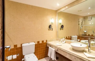 a bathroom with a toilet and a sink and a mirror at Hurghada Coral Beach Hotel in Hurghada