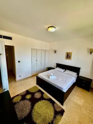 a bedroom with a large bed in a room with a rug at New Marina MP 37 in Hurghada
