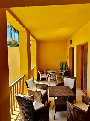 a balcony with chairs and tables and yellow walls at New Marina MP 37 in Hurghada