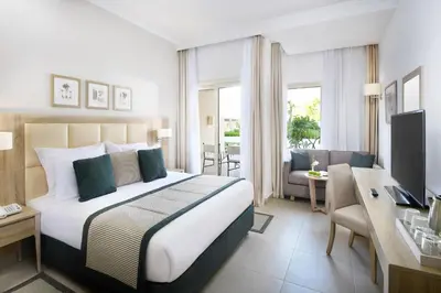 a hotel room with a large bed and a desk at JAZ Elite Casa Del Mar Beach in Hurghada