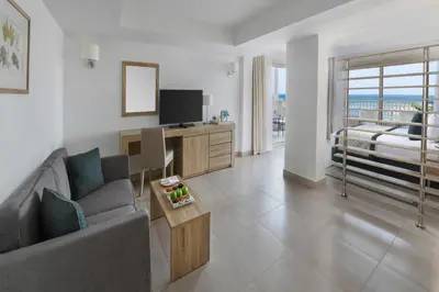 a living room with a couch and a tv at JAZ Elite Casa Del Mar Beach in Hurghada