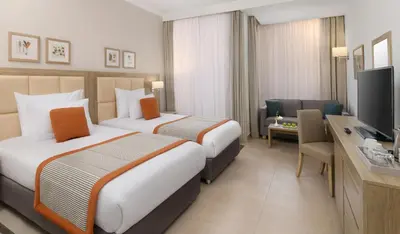 a hotel room with two beds and a television at JAZ Elite Casa Del Mar Beach in Hurghada