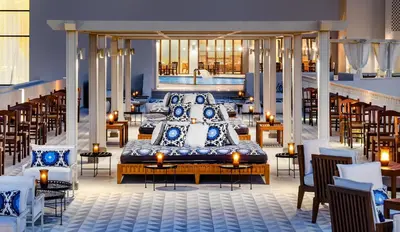 a room with a bed with blue and white pillows at JAZ Elite Casa Del Mar Beach in Hurghada