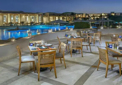 a restaurant with tables and chairs next to a pool at Iberotel Casa Del Mar Resort in Hurghada