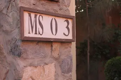 a sign on the side of a stone wall at El Gouna 2 bedrooms apartment South Marina Ground Floor in Hurghada