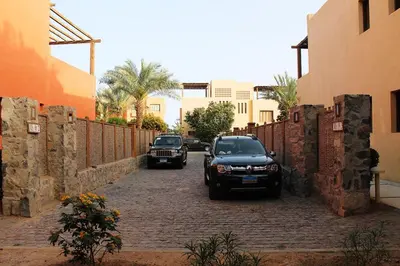 two cars parked on a brick road next to a fence at El Gouna 2 bedrooms apartment South Marina Ground Floor in Hurghada