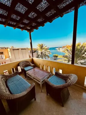 a balcony with chairs and tables and a view of the ocean at Aprtment at Abu Tig Marina - MP6 in Hurghada