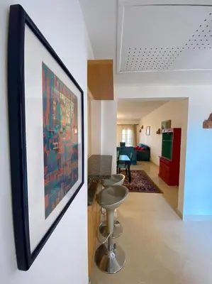 a living room with a painting on the wall and a living room at Aprtment at Abu Tig Marina - MP6 in Hurghada