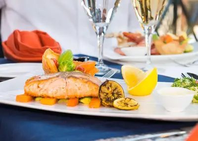 a plate with a fish and vegetables on a table at Hilton Marsa Alam Nubian Resort in Abu Dabab