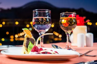 a table with a plate of food and two glasses of wine at Hilton Marsa Alam Nubian Resort in Abu Dabab