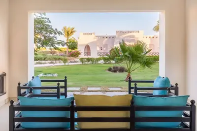 a bedroom with a view of a yard at Hilton Marsa Alam Nubian Resort in Abu Dabab