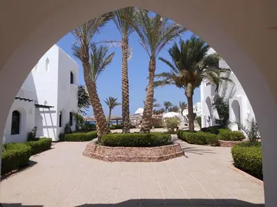 an archway leading to a courtyard with palm trees at Arabella Azur Resort in Hurghada