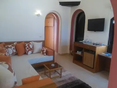 a living room with a couch and a tv at Arabella Azur Resort in Hurghada