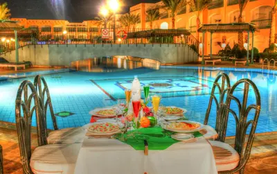 a table and chairs in front of a swimming pool at Bel Air Azur Resort (Adults Only) in Hurghada