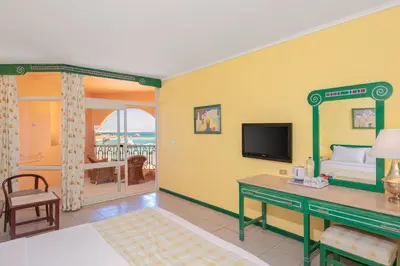 a room with a bed and a desk and a television at Giftun Azur Resort in Hurghada