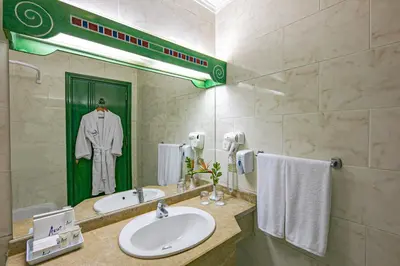 a bathroom with a sink and a robe on a mirror at Giftun Azur Resort in Hurghada