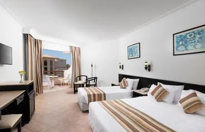 a hotel room with two beds and a living room at JAZ Palmariva Beach in Hurghada