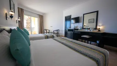 a hotel room with two beds and a sink at JAZ Palmariva Beach in Hurghada