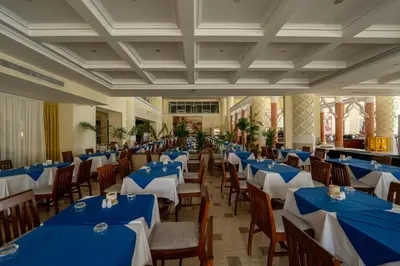 a banquet hall with blue tables and chairs at JAZ Royal Palmariva in Hurghada
