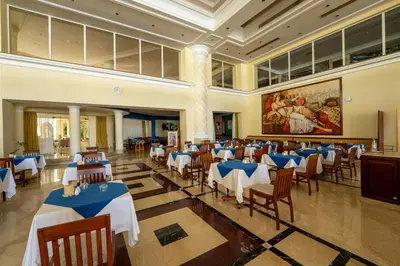 a dining room with tables and chairs in a building at JAZ Royal Palmariva in Hurghada