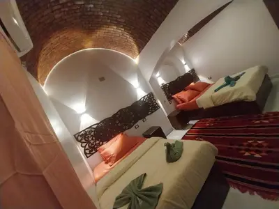 a small room with two beds and a mirror at Queen House in Aswan