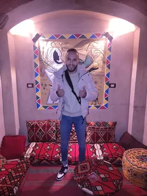 a man standing in front of a room with beds at Queen House in Aswan
