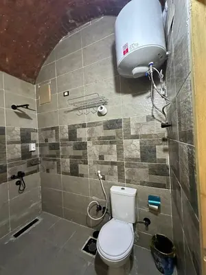 a bathroom with a toilet and a water tank at Queen House in Aswan