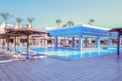 a pool at a resort with chairs and umbrellas at Blend Club Aqua Resort in Hurghada
