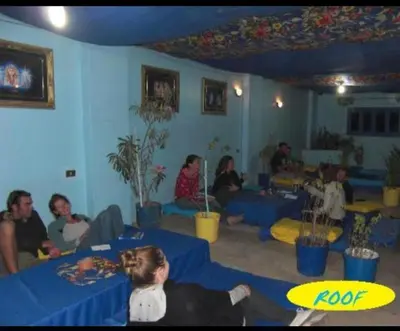 a group of people sitting in a room with blue tables at Oasis hotel in Luxor