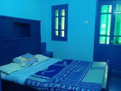 a blue bedroom with a bed and a window at Oasis hotel in Luxor