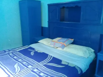 a blue bedroom with a bed with a blue headboard at Oasis hotel in Luxor
