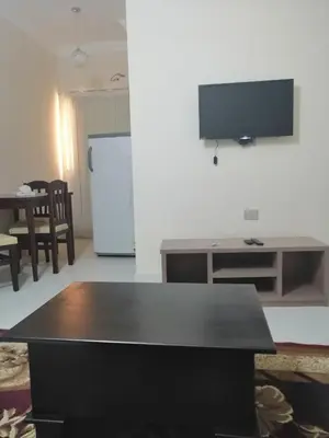 a living room with a table and a television on a wall at Nour Plaza Hurghada النور بلازا الغردقة in Hurghada