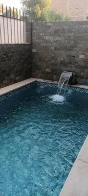 a swimming pool with a water fountain in it at Villa Dream in Luxor