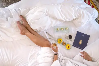 a woman laying on a bed with her legs on the bed at The Oberoi Beach Resort, Sahl Hasheesh in Hurghada