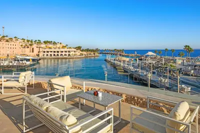 a patio with chairs and a table and a marina at Pickalbatros Citadel Resort Sahl Hasheesh in Hurghada