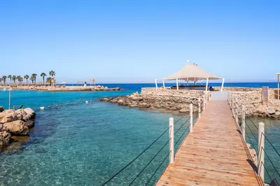 a boardwalk leading to a beach with the ocean at Pickalbatros Citadel Resort Sahl Hasheesh in Hurghada