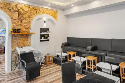 a barber shop with black furniture and a stone wall at Pickalbatros Citadel Resort Sahl Hasheesh in Hurghada