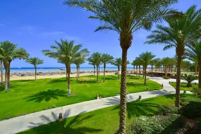 a park with palm trees and the beach at Stella Beach Resort & Spa, Makadi Bay in Hurghada