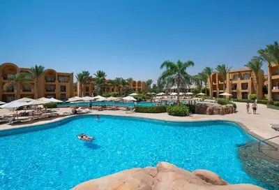 a pool at a resort with people swimming in it at Stella Beach Resort & Spa, Makadi Bay in Hurghada