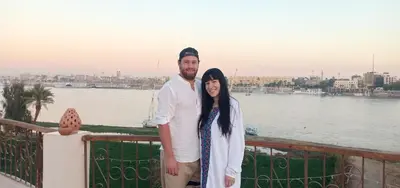 a man and a woman standing next to a body of water at Luxor Plaza House in Luxor