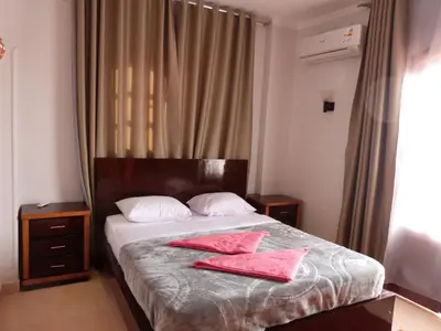 a bedroom with a bed with two pink towels on it at Luxor Plaza House in Luxor