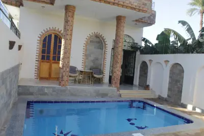 a house with a swimming pool in the yard at Nour House in Luxor
