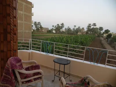 a balcony with chairs and a view of a field at Nour House in Luxor