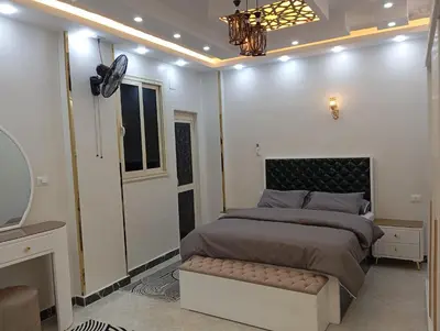 a bedroom with a large bed and a mirror at Nour House in Luxor